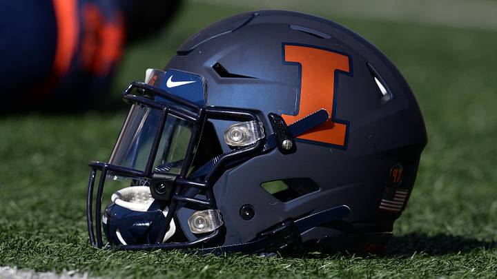 Oct 12, 2019; Champaign, IL, USA; An Illinois Fighting Illini helmet sits on the field as players stretch before the start of the game between the Illinois Fighting Illini and the Michigan Wolverines at Memorial Stadium. Mandatory Credit: Michael Allio-Imagn Images