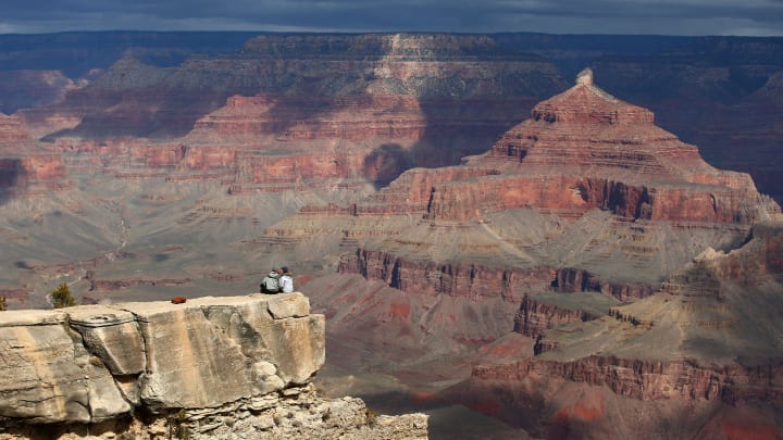 Collin Carter and Emma Griggs (right), two seasonal employees at Crested Butte Mountain Resort ski resort in Colorado kiss at Mather Point in Grand Canyon National Park on Mar. 18, 2020.