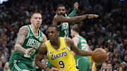 Los Angeles Lakers guard Rajon Rondo drives the ball against Boston Celtics guard Kyrie Irving and forward Daniel Theis