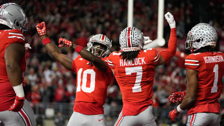 Nov 18, 2023; Columbus, Ohio, USA; Ohio State Buckeyes cornerback Jordan Hancock (7) and cornerback Denzel Burke (10) celebrate an interception by Hancock during the second half of the NCAA football game against the Minnesota Golden Gophers at Ohio Stadium. Ohio State won 37-3.