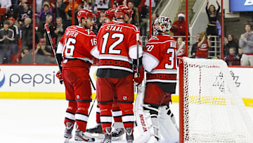 December 26, 2011; Raleigh, NC, USA; Carolina Hurricanes goalie Cam Ward (30) is congratulated by teammates center Eric Staal (12) and center Brandon Sutter (16) after scoring a third period goal against the New Jersey Devils at the RBC center. The Hurricanes defeated the Devils 4-2. Mandatory Credit: James Guillory-Imagn Images