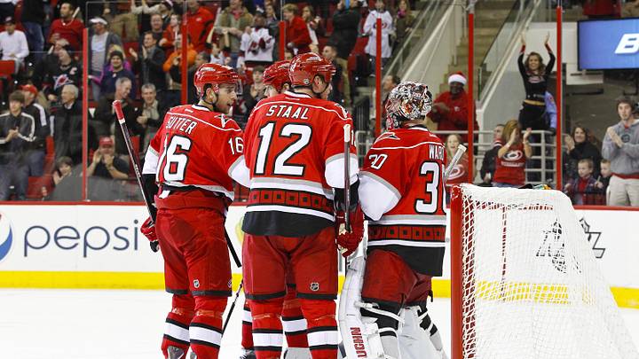 December 26, 2011; Raleigh, NC, USA; Carolina Hurricanes goalie Cam Ward (30) is congratulated by teammates center Eric Staal (12) and center Brandon Sutter (16) after scoring a third period goal against the New Jersey Devils at the RBC center. The Hurricanes defeated the Devils 4-2. Mandatory Credit: James Guillory-Imagn Images