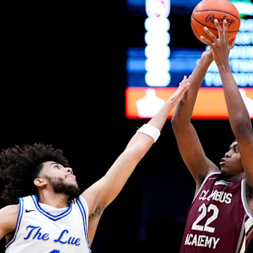 TJ Crumble, left, competes for the Lutheran East varsity boys basketball team during the Division V championship game against Columbus Academy at the University of Dayton Arena in March.