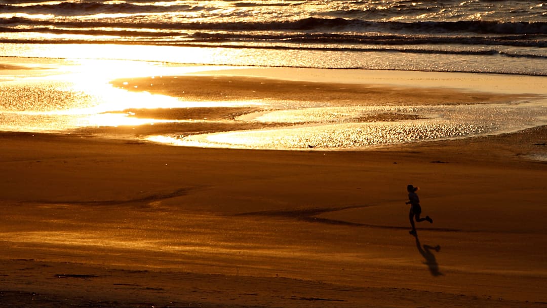 Runner on the beach at sunrise