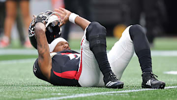 Michael Penix Jr. of the Atlanta Falcons takes his helmet off after a play against the Carolina Panthers.