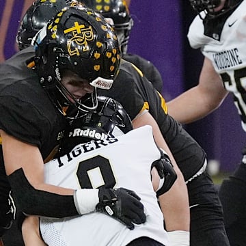 Bishop Garrigan defensive end Madden Miller (46) takes down Woodbine running back Micah Moores (9) during the second quarter in the 8-players state football championship on Nov. 20, 2025, at UNI Dome in Cedar Falls, Iowa.