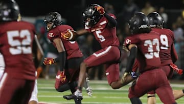Oaks Christian's Davon Benjamin leaps through an opening after making an interception of a St. Bonaventure pass during the third quarter of the Marmonte League title game on Friday, Oct. 27, 2023, at Oak Christian's Thorson Stadium. Oaks Christian won 13-10.