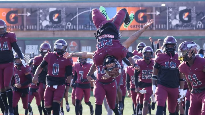 Juan Rodriguez of Miami Norland (Fla.) does a backflip while leading his teammates onto the field before the start of the FHSAA 2M state football championship game at Bragg Memorial Stadium in Tallahassee.