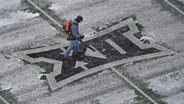 The K-State grounds crew clear snow off the field in preparation for the Big 12 matchup between Iowa State and Kansas State