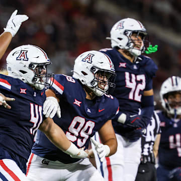 Aug 30, 2025; Tucson, Arizona, USA; Arizona Wildcats defensive lineman Leroy Palu (95), defensive lineman Julian Savaiinaea (41), defensive lineman Mays Pese (99), and defensive lineman Dominic Lolesio (42) all celebrate after they intercept the ball from the Hawaii Rainbow Warriors during the third quarter at Arizona Stadium. Mandatory Credit: Aryanna Frank-Imagn Images