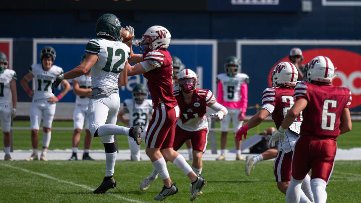 In a sea of red Worcester Academy's Griffin Collins intercepts a ball intended for Berkshire School's Daniel Echeverri on Sunday October 1, 2023 at Polar Park in Worcester. Collins returned the ball for a Hilltoppers touchdown.