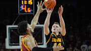 Iowa Hawkeyes guard Bennett Stirtz (14) takes a three-point shot over Iowa State Cyclones forward Joshua Jefferson (5) during the first half in the men’s basketball Cy-Hawk series on Dec. 11, 2025, in Ames, Iowa.