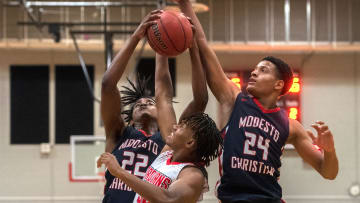 Lincoln's Beau Blackman, center, fights for a rebound with Modesto Christian's Myles  Clayton, left, and Jamari Phillips during a boys varsity basketball game at Lincoln High School  in Stockton.

Winterexamples 012