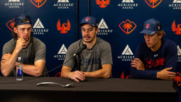 Coachella Valley forward Andrew Poturalski (center) talks about his team's win joined by forward Kole Lind (left) and defenseman Ryker Evans joined by a single silver spoon on the table after Game 2 of the Western Conference Finals at Acrisure Arena in Palm Desert, Calif., Friday, May 31, 2024.