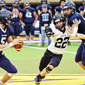 Bedford senior quarterback Conner Nally (5) is forced to rush his pass as the Bishop Garrigan (Algona) Golden Bears compete against the Bedford Bulldogs for the Eight-Player championship on Thursday, November 16, 2023 at the UNI-Dome in Cedar Falls.