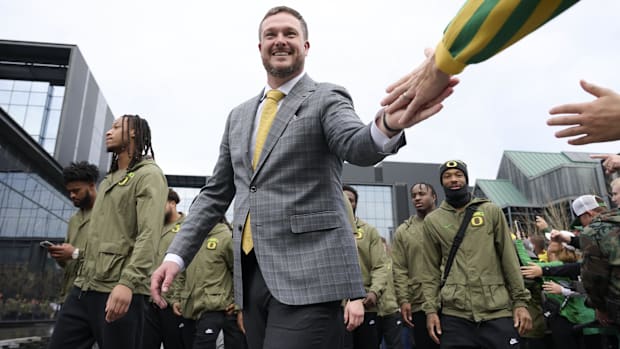 Oregon Ducks head coach Dan Lanning high-fives fans before a game against the Maryland Terrapins at Autzen Stadium. Mandat