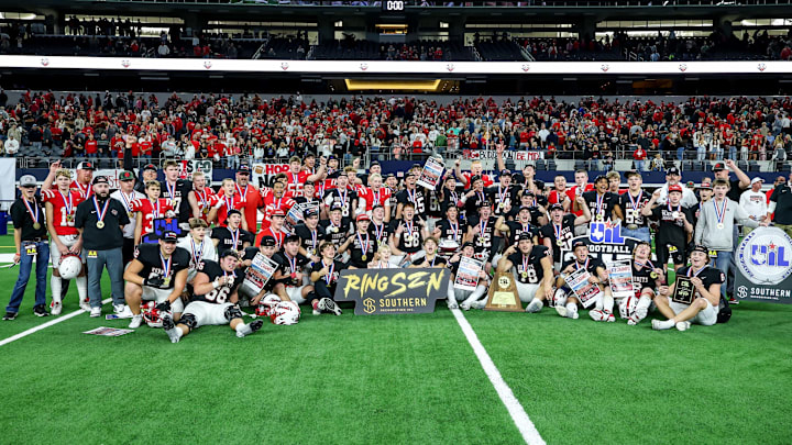 Muenster players and coaches pose following their victory in the Texas 2A Division 2 state title game at AT&T Stadium.