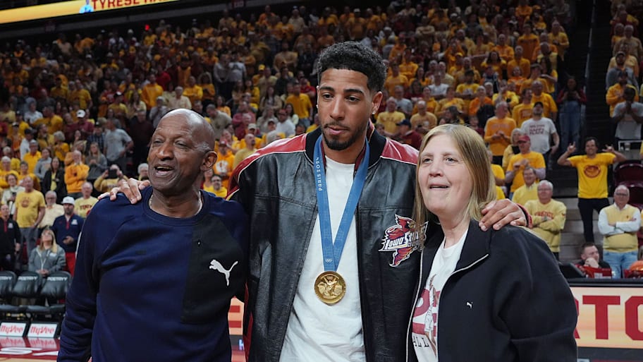Former Iowa State and Indiana Packer guard Tyrese Haliburton holds his parents John and Brenda Haliburton as the unveiling his Olympic '24 gold medal banner. | Nirmalendu Majumdar/Ames Tribune / USA TODAY NETWORK via Imagn Images