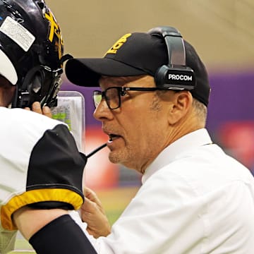 Bishop Garrigan (Algona) sophomore quarterback Tate Foertsch (7) listens to Bishop Garrigan (Algona) Head Coach Marty Wadle as the Bishop Garrigan (Algona) Golden Bears compete against the Bedford Bulldogs for the Eight-Player championship on Thursday, November 16, 2023 at the UNI-Dome in Cedar Falls.