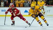 Sam Harris (12) of the Denver Pioneers follows Cruz Lucius (51) of the Arizona State Sun Devils down the ice as they play 3-on-3 in overtime at Mullett Arena on Feb. 8, 2025, in Tempe, Ariz.
