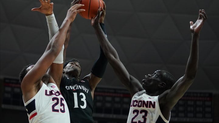 Feb 9, 2020; Storrs, Connecticut, USA; Cincinnati Bearcats forward Tre Scott (13) works for the rebound against Connecticut Huskies forward Akok Akok (23) and center Josh Carlton (25) in overtime at Harry A. Gampel Pavilion. UConn defeated Cincinnati in overtime 72-71. Mandatory Credit: David Butler II-USA TODAY Sports