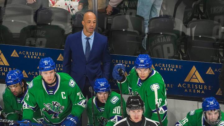 Abbotsford head coach Manny Malhotra watches his team from the bench during the first period of their game at Acrisure Arena in Palm Desert, Calif., Wednesday, Jan. 29, 2025.