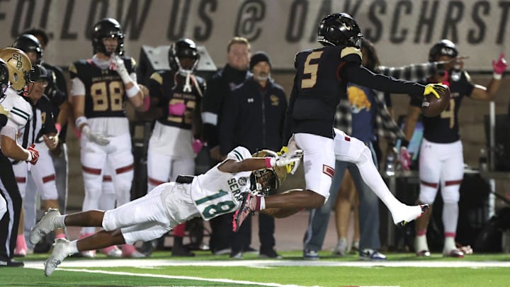 Oaks Christian's Davon Benjamin leaps free from St. Bonaventure's Darrien Johnson return an interception for a touchdown in the third quarter of Oaks Christian's win over visiting St. Bonaventure Friday at Redell Field. The Lions won, 35-0.