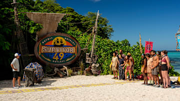 “I’m a Wolf, Baby” – One castaway’s scheming gets them into hot water when their tribe realizes the same conversation has been repeated to each of them. Two castaways are sent on a grueling journey. Then, one castaway’s series of missteps leaves one of their tribemates hungry for revenge, on SURVIVOR, Wednesday, Oct. 22. Pictured (L-R): Jeff Probst and Survivor 49 contestants. Photo: Robert Voets/CBS ©2025 CBS Broadcasting, Inc. All Rights Reserved.