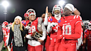 Mater Dei football players are all smiles with the 2024 CIF State Open Division trophy after beating De La Salle 37-15 at Saddleback College in Mission Viejo.