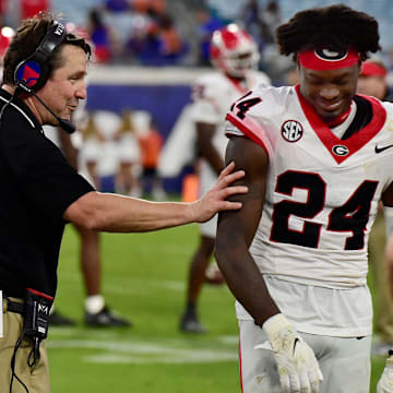 Georgia Bulldogs co-defensive coordinator and former Gator head coach Will Muschamp shares a smile with Georgia Bulldogs defensive back Malaki Starks (24) as the clock ticks down on Georgia's lopsided victory over the Gators at the annual Florida vs Georgia football game at EverBank Stadium in Jacksonville, FL, Saturday, October 27, 2023. Georgia walked away with a final score of 43 to 20. [Bob Self/Florida Times-Union]
