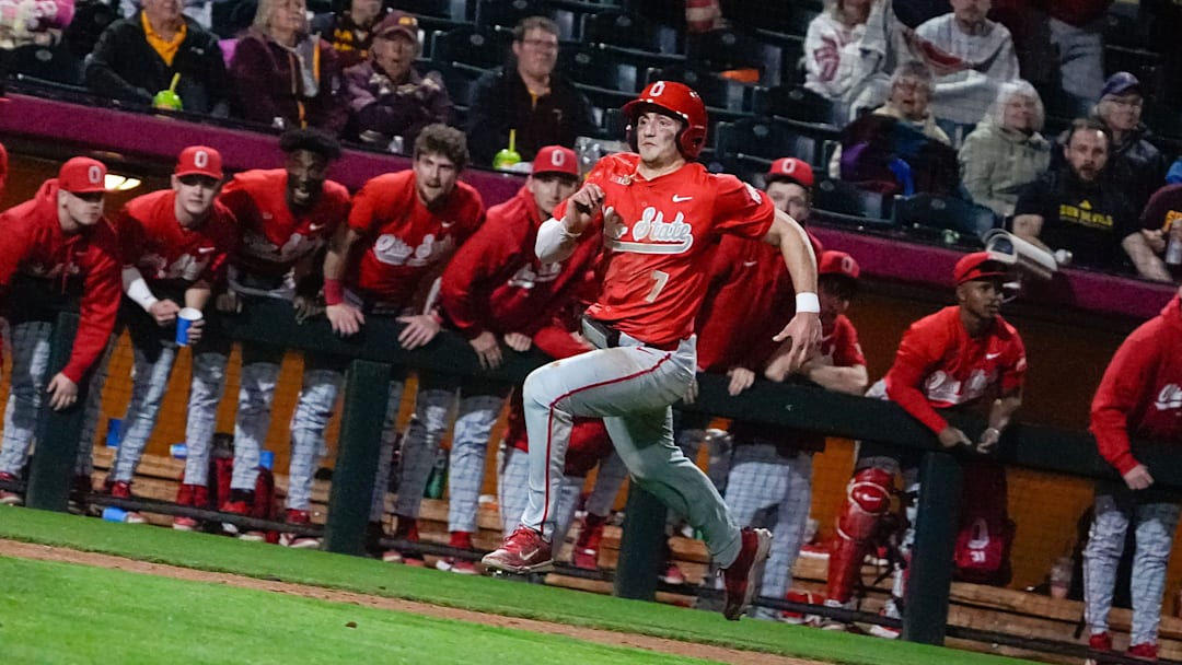 The Ohio State dugout cheers as Nick Giamarusti (7) runs toward home plate during a game against Arizona State at Phoenix Municipal Stadium on Feb. 14, 2025, in Phoenix, Ariz.