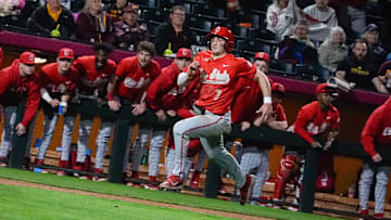 The Ohio State dugout cheers as Nick Giamarusti (7) runs toward home plate during a game against Arizona State at Phoenix Municipal Stadium on Feb. 14, 2025, in Phoenix, Ariz.