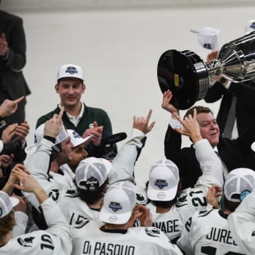 Michigan State hockey coach Adam Nightingale hoists the Big Ten tournament championship trophy after the Spartans beat Michigan 5-4 in overtime in Saturday night's title game at Munn Ice Arena in East Lansing.
