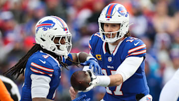 Buffalo Bills quarterback Josh Allen hands the ball to running back James Cook against the Denver Broncos in the Wild Card Round