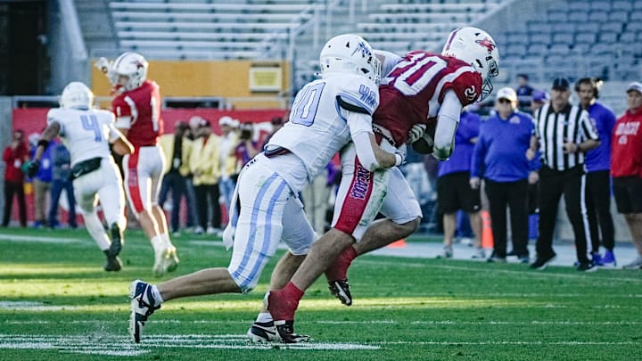 Chase Jones (40) of the Mica Mountain Thunderbolts tackles Ryan Jimenez (20) of the Arcadia Titans during the 4A state championship game at Mountain America Stadium on Dec. 5, 2025, in Tempe. Chase Jones (40) of the Mica Mountain Thunderbolts tackles Ryan Jimenez (20) of the Arcadia Titans during the 4A state championship game at Mountain America Stadium on Dec. 5, 2025, in Tempe.