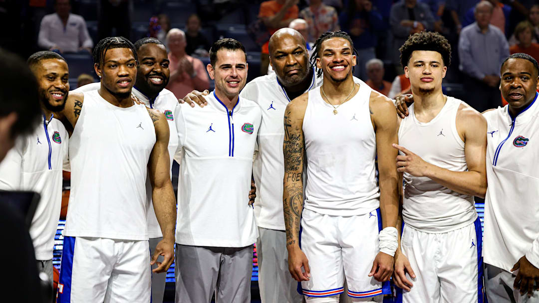 Florida Gators seniors Alijah Martin, Will Richard and Walter Clayton Jr. pose with coaches Taurean Green, Todd Golden, Carlin Hartman and Korey McCray during the Senior Night ceremony.
