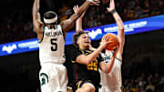 Dec 4, 2024; Minneapolis, Minnesota, USA; Minnesota Golden Gophers guard Lu'Cye Patterson (25) shoots as Michigan State Spartans guard Tre Holloman (5) and center Carson Cooper (15) defend during the first half at Williams Arena. Mandatory Credit: Matt Krohn-Imagn Images
