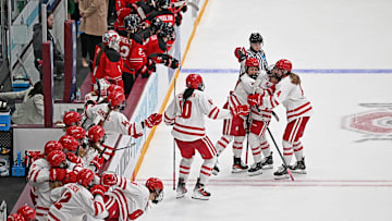 Wisconsin right wing Kirsten Simms (27) is mobbed by teammates after scoring on a penalty shot with 18.9 seconds left to tie the NCAA women's hockey Frozen Four championship game Sunday, March 23, 2025, at Ridder Arena in Minneapolis, Minnesota.