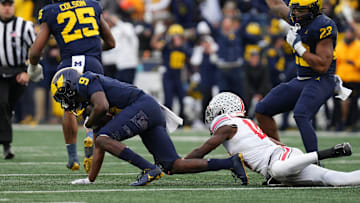 Nov 25, 2023; Ann Arbor, Michigan, USA; Michigan Wolverines defensive back Rod Moore (9) intercepts a pass intended for Ohio State Buckeyes wide receiver Marvin Harrison Jr. (18) near the end of the second half of the NCAA football game at Michigan Stadium. Ohio State lost 30-24.