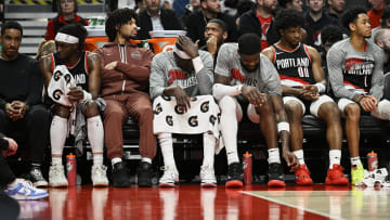 Mar 11, 2024; Portland, Oregon, USA; The Portland Trail Blazers bench, from left, guard Malcolm Brogdon (11), guard Shaedon Sharpe (17), center Duop Reath (26), center Deandre Ayton (2), guard Scoot Henderson (00), and guard Anfernee Simons (1) watch the final minutes of a game against the Boston Celtics at Moda Center. Mandatory Credit: Troy Wayrynen-USA TODAY Sports