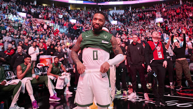 Milwaukee Bucks guard Damian Lillard listens as fans applaud his return to Portland during the 2023-24 season.