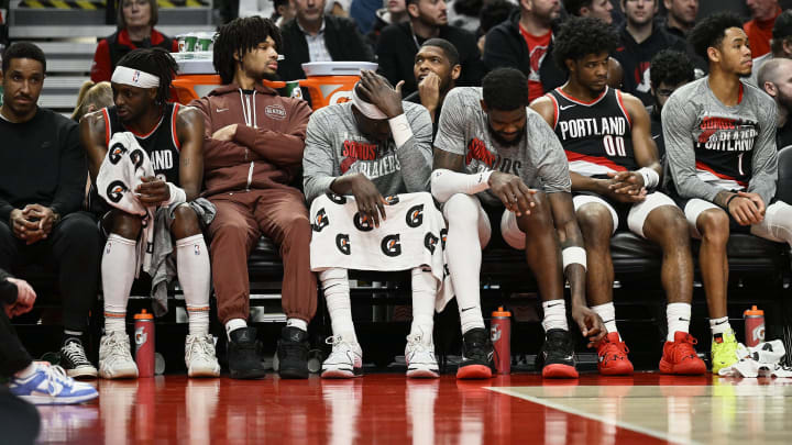 Mar 11, 2024; Portland, Oregon, USA; The Portland Trail Blazers bench, from left, guard Malcolm Brogdon (11), guard Shaedon Sharpe (17), center Duop Reath (26), center Deandre Ayton (2), guard Scoot Henderson (00), and guard Anfernee Simons (1) watch the final minutes of a game against the Boston Celtics at Moda Center. Mandatory Credit: Troy Wayrynen-USA TODAY Sports