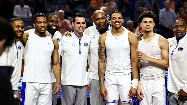Florida Gators seniors Alijah Martin, Will Richard and Walter Clayton Jr. pose with coaches Taurean Green, Todd Golden, Carlin Hartman and Korey McCray during the Senior Night ceremony.
