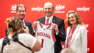 Indiana University Vice President and Director of Intercollegiate Athletics Scott Dolson, Indiana University men's basketball Head Coach Darian DeVries and Indiana University President Pamela Whitten pose with a jersey at the introductory press conference at Simon Skjodt Assembly Hall on Wednesday, March 19, 2025.