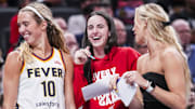 Indiana Fever guards Lexie Hull, Caitlin Clark, and Sophie Cunningham laugh near the team bench during a game against the Washington Mystics.