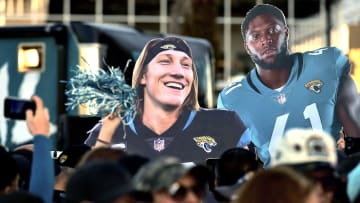 Oversized photos of Jacksonville Jaguars quarterback Trevor Lawrence (16) and teammate linebacker Josh Allen (41) are carried behind the crowd as they waited for the team to leave the stadium Friday morning. 