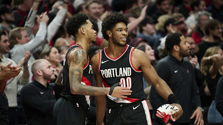 Jan 31, 2024; Portland, Oregon, USA; Portland Trail Blazers guard Scoot Henderson (00) celebrates with guard Anfernee Simons (1) during the second half against the Milwaukee Bucks at Moda Center. Mandatory Credit: Troy Wayrynen-Imagn Images