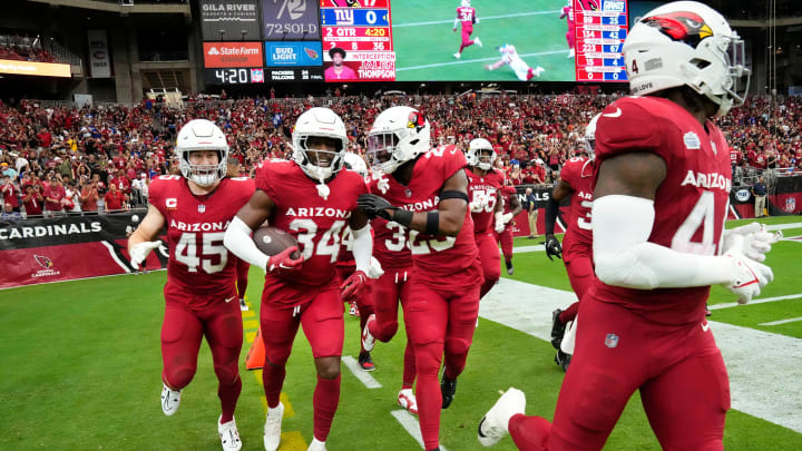 Sep 17, 2023; Glendale, AZ, USA; Arizona Cardinals safety Jalen Thompson (34) celebrates his interception as it plays on the big screen against the New York Giants in the first half at State Farm Stadium. Mandatory Credit: Rob Schumacher-Arizona Republic