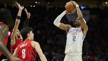 Jan 26, 2025; Portland, Oregon, USA; Oklahoma City Thunder guard Shai Gilgeous-Alexander (2) shoots a jump shot during the second half against Portland Trail Blazers forward Deni Avdija (8) and forward Toumani Camara (33) at Moda Center. Mandatory Credit: Troy Wayrynen-Imagn Images