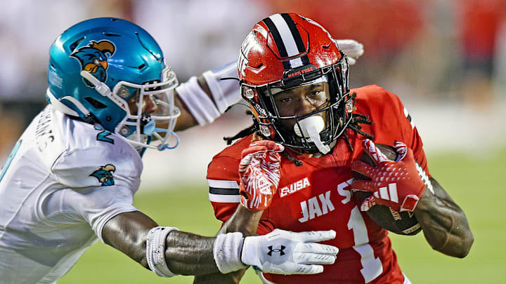 Jacksonville State's Demarcus Lacey tries to evade the tackle of Coastal Carolina's Courtney Eubanks during college football action at Burgess-Snow Field AmFirst Stadium in Jacksonville, Alabama August 29, 2024. (Dave Hyatt / Special to the Gadsden Times)